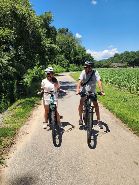 Couple on e-bikes on a sunny countryside path